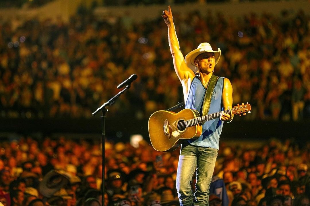 Kenny Chesney performing under warm stage lights